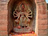 Kathmandu Changu Narayan 35 Figure With Eight Arms That I Think Is Durga Is On East Side Of Parijat Tree Platform On North East Side Of Changu Narayan A rough statue of a figure with eighth arms that I think is Durga is on the east side of the parijat tree platform in the north east area of Changu Narayan. It is hard to make out what the arms are holding.